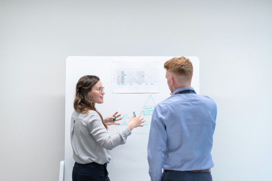 Home builder office team: two colleagues planning at a whiteboard