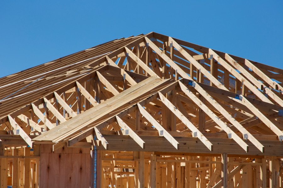 Growing regional home builder: wood roof trusses framing a new house